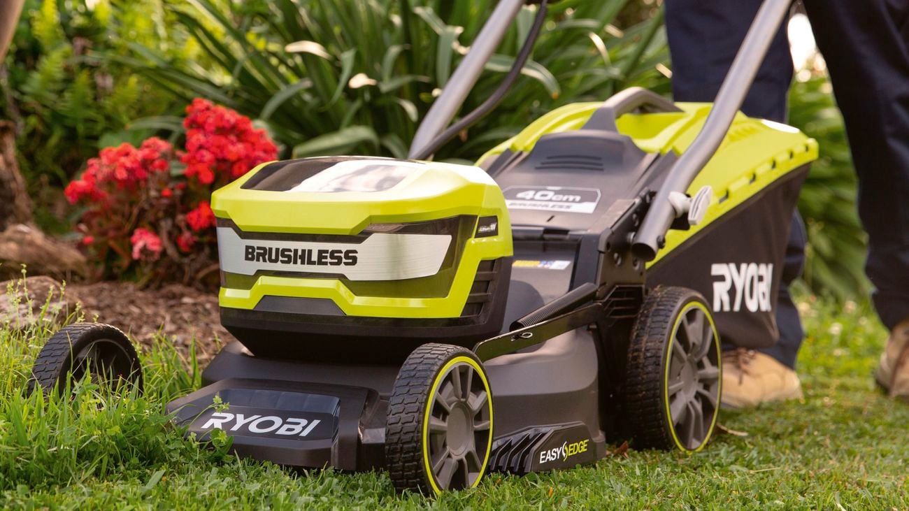 A man uses a Ryobi 40cm HP™ brushless lawn mower to mow grass