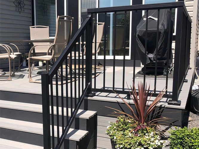 Outdoor porch area with furniture and a black aluminium balastrade.