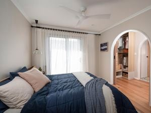 Bedroom with bed in it, a ceiling fan and a picture on the wall