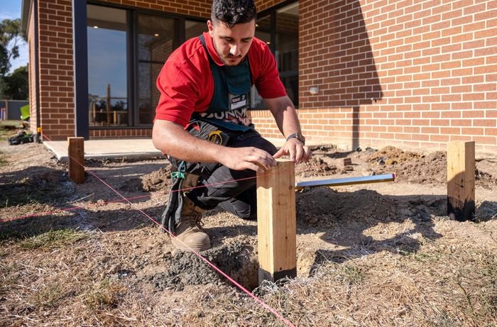 Man placing stump in the hole.