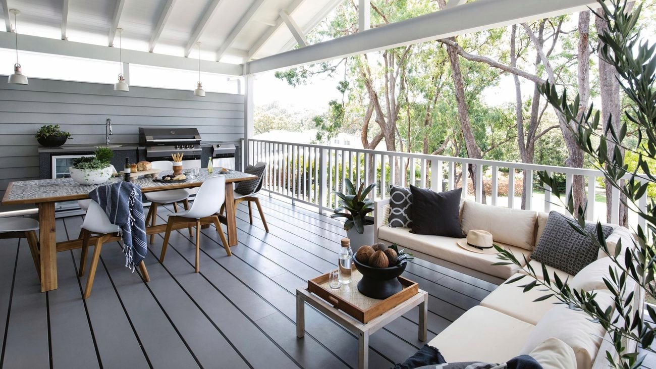 Outdoor area featuring dining and lounge furniture, and BBQ, on top of grey deck.