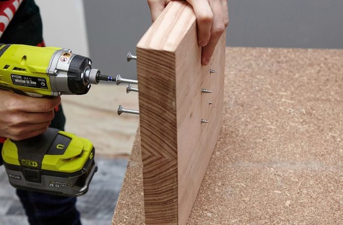 Screws being positioned at the base of the wooden coat rack
