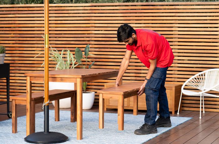 Outdoor deck divided into dining and relaxation zones with furniture and shade umbrella.
