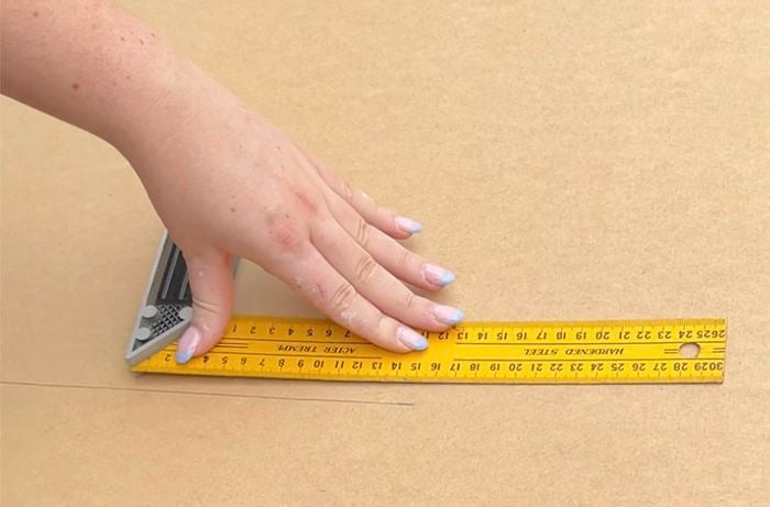 Hand using ruler to join centre marks together