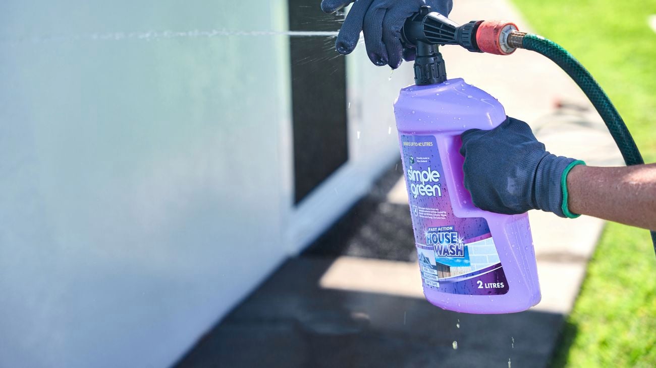 Purple Simple Green wash product being sprayed by hands in gloves