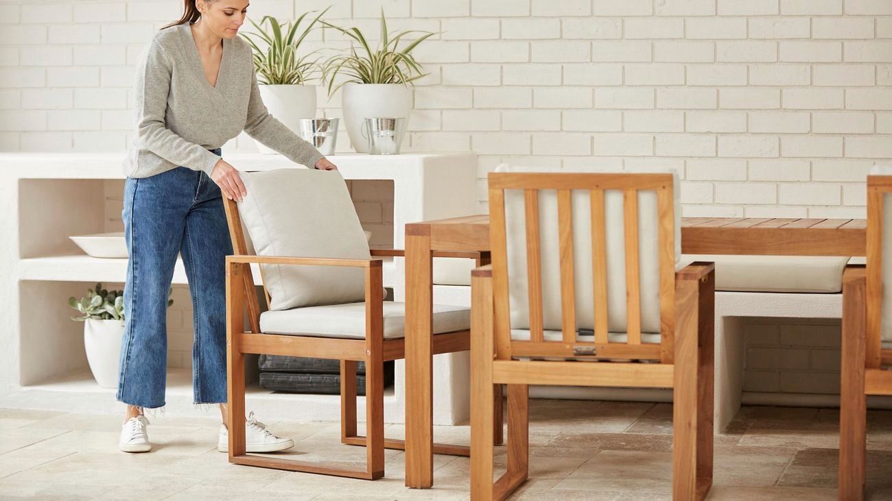 Woman adjusts a timber outdoor dining chair