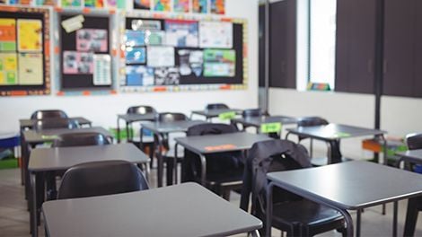A classroom with rows of tables and chairs