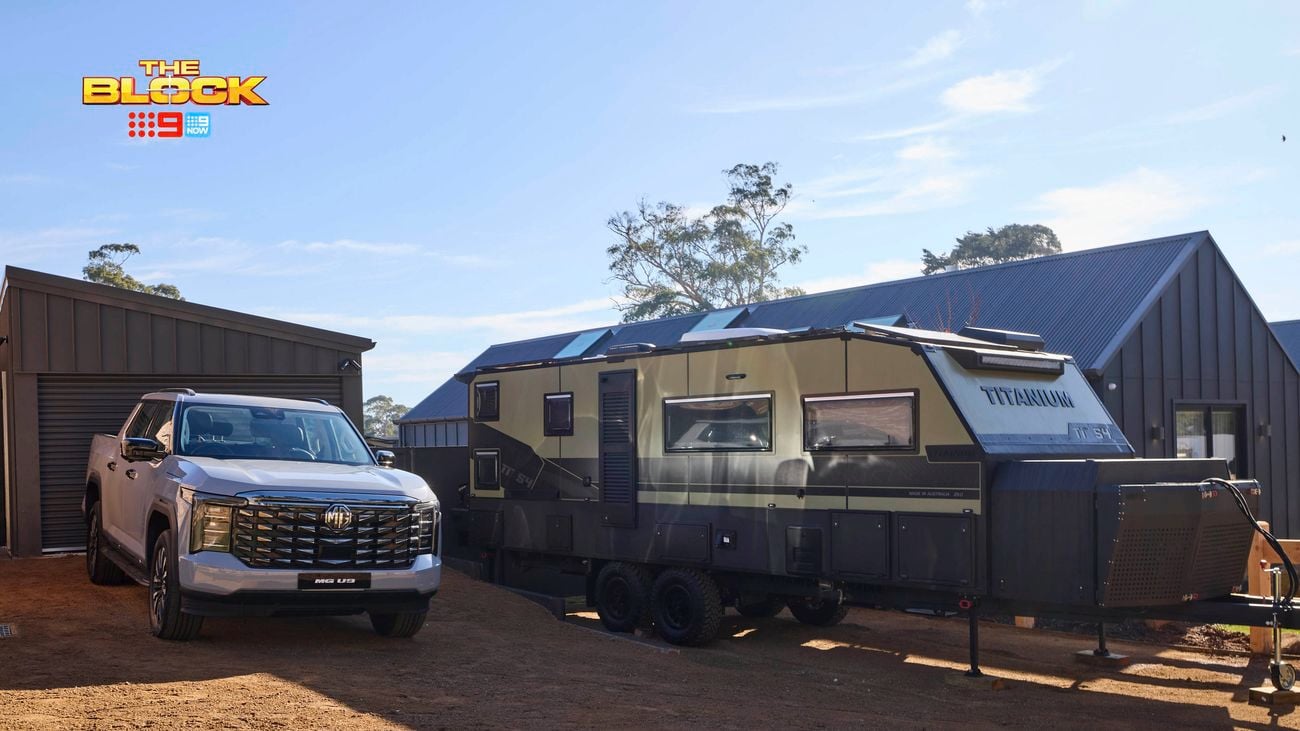 A house with a car and a caravan in the driveway out the front of it.