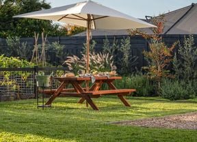Picnic bench with an umbrella in the backyard on a sunny day