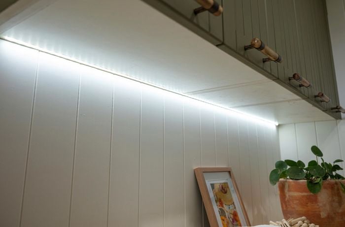 Under-cabinet lights illuminating the laundry room.