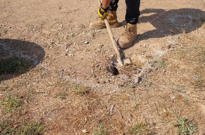 Man digging hole with shovel. 