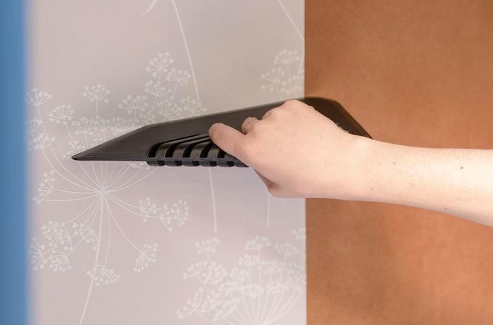 Applying wallpaper to inside of wardrobe