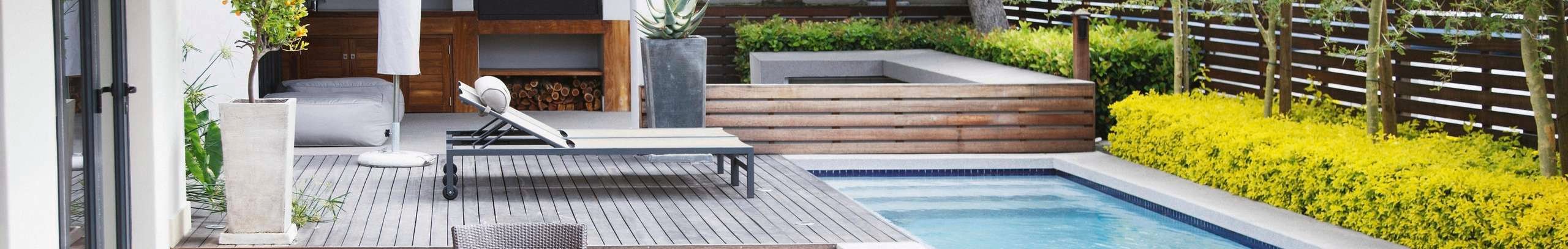 Large, modern backyard with decking, a pool and turf