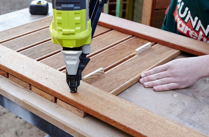 Person using a fixing gun on timber.