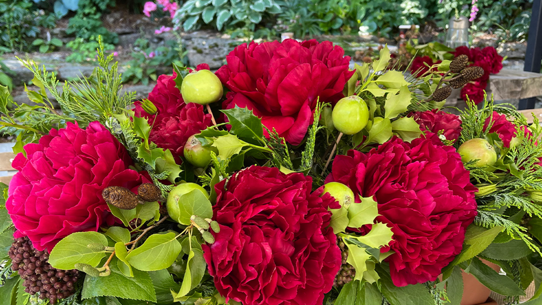 Festive tabletop setting with red flowers and green foliage