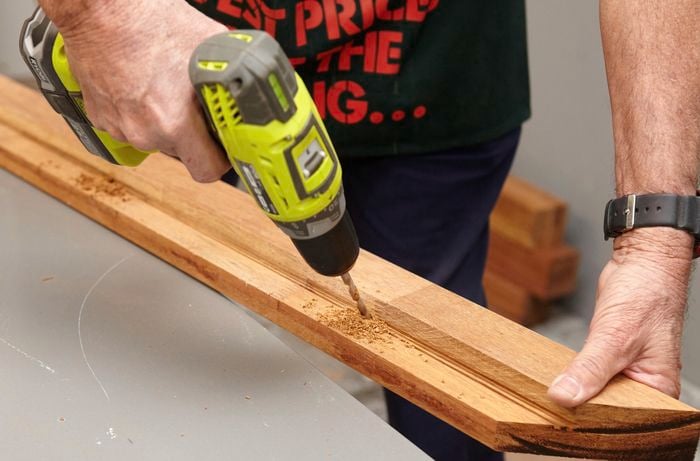 Person drilling into a thin bit of timber.