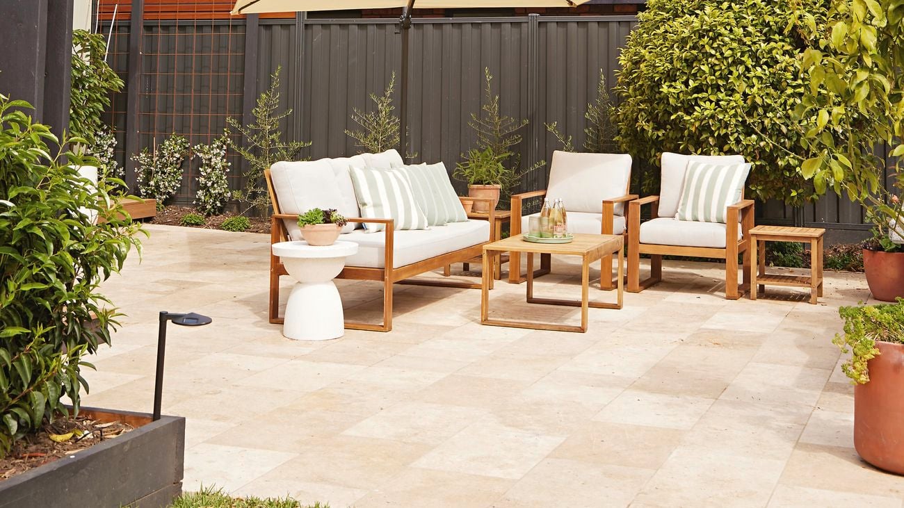 Outdoor patio setting with an umbrella, two chairs and a lounge.