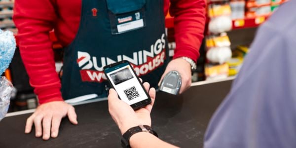 Bunnings team member preparing to scan PowerPass app on customers phone.