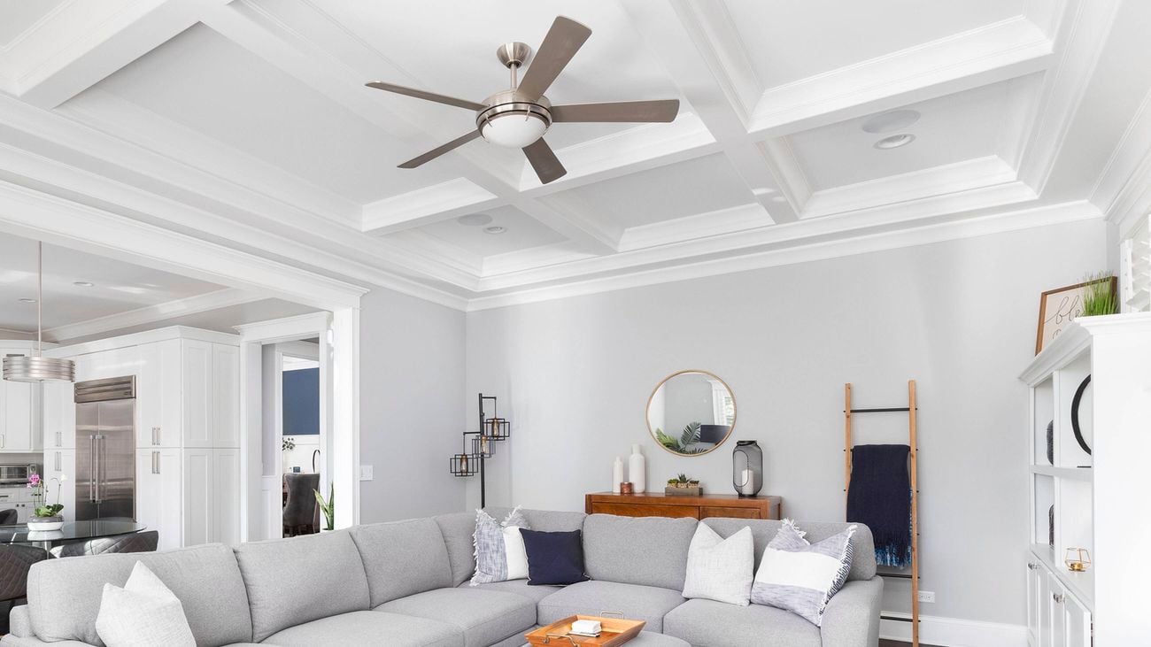 A light coloured living room with a ceiling fan being used as a way to save money on household bills Australia