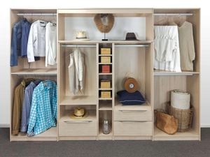 Open wardrobe with a light-coloured wood finish. In the wardrobe is an assortment of clothes, hats, bags and accessories.