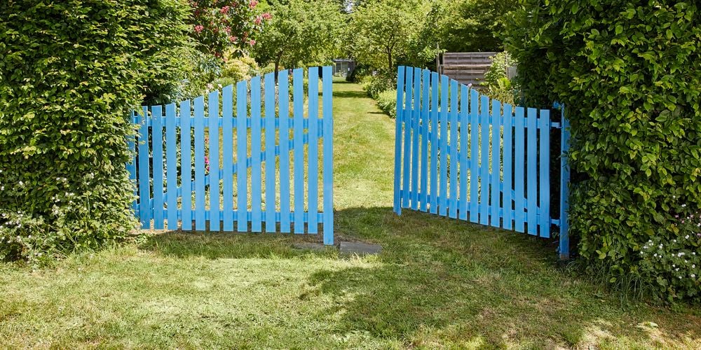 Finished result of a picket fence painted in baby blue.