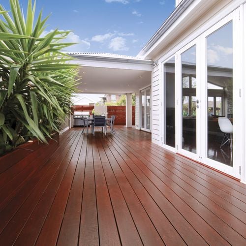 Outdoor dining setting on stained decking in an outdoor entertaining area