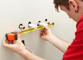 A Bunnings team member measuring the position of the water pipes.