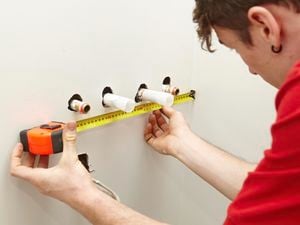 A Bunnings team member measuring the position of the water pipes.
