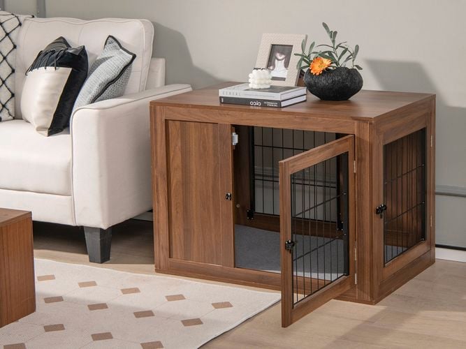 Walnut wooden dog crate end table with open door in a living room.