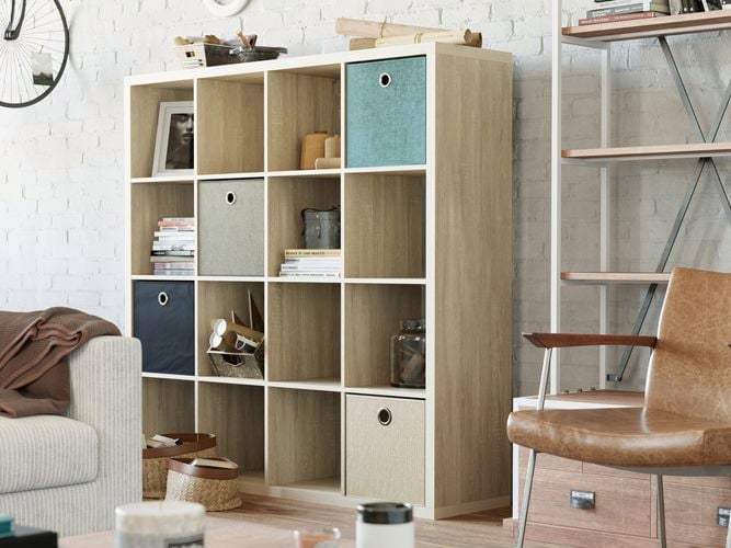 A cube shelving unit, chair, couch and racking against a wall