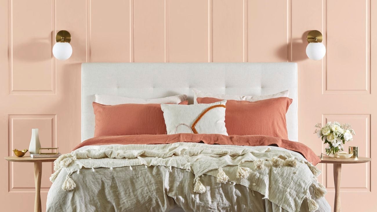 Classic bedroom with pink wall panelling and bed.