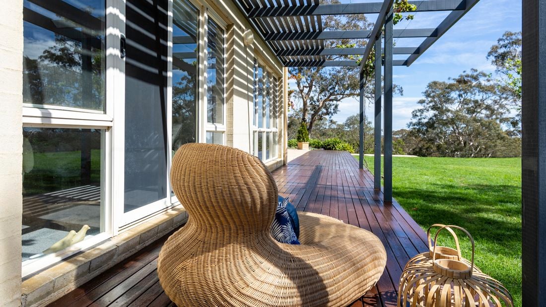 Backyard patio with seating and columns by Vuepro