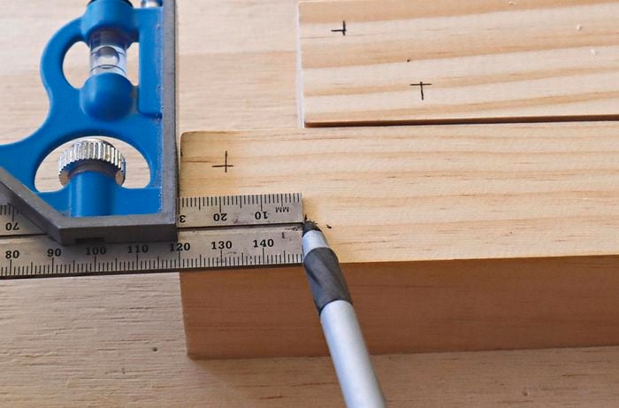 A square rule and pen used to mark out a piece of timber