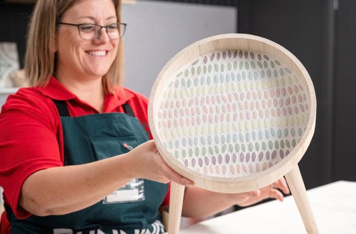 A Bunnings Team Member holding a mosaic side table