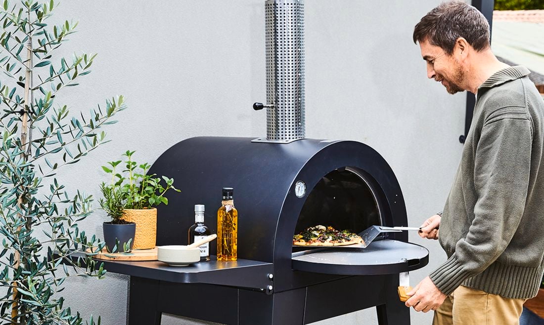 Pizza oven being used by man