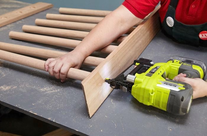 Person using nail gun to nail piece of timber together