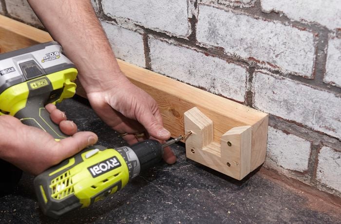 Person attaching bracket to timber.