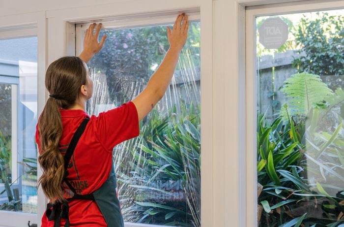 A Bunnings Team Member holding a piece of film against a window