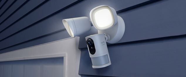 Security camera attached to exterior of house with two floodlights