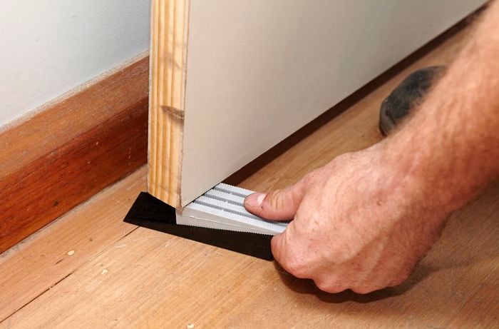 A pair of door wedges being used to keep a door stable as it is secured onto hinges