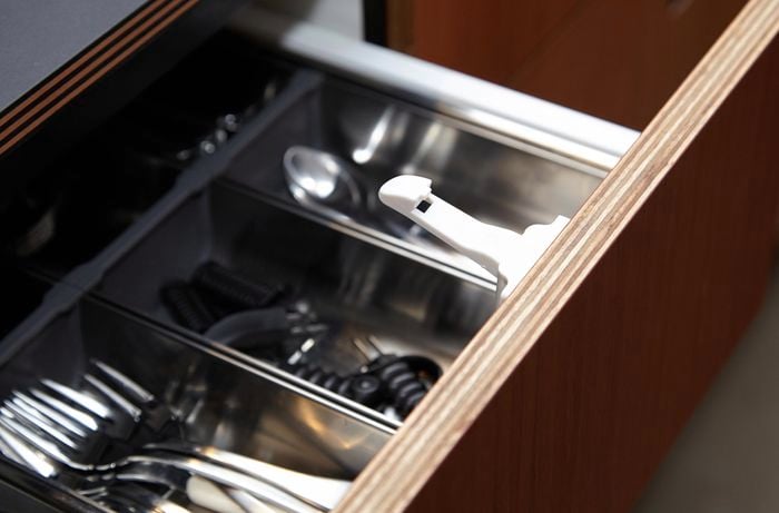 Open drawer with a white hook on it, that is used to prevent it from opening fully.