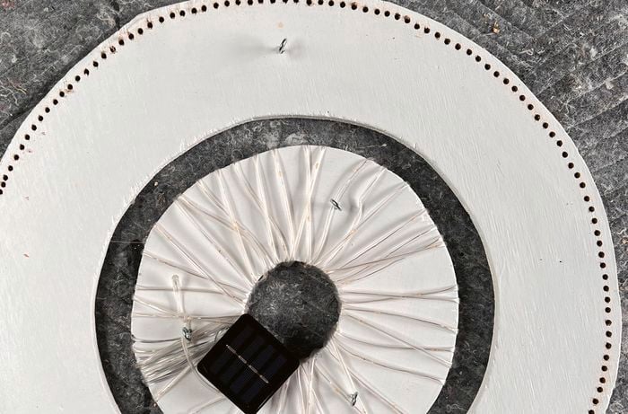 A small circle frame with a solar light box positioned inside a large circle frame