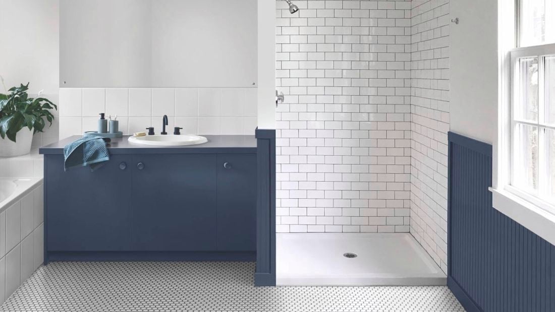 A bathroom with shower and base coloured blue