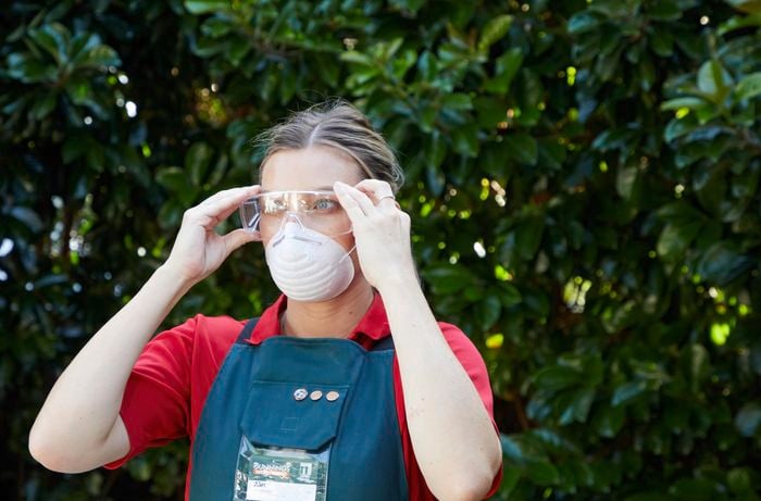 A woman wearing a safety mask and eye protection for a D.I.Y. project.