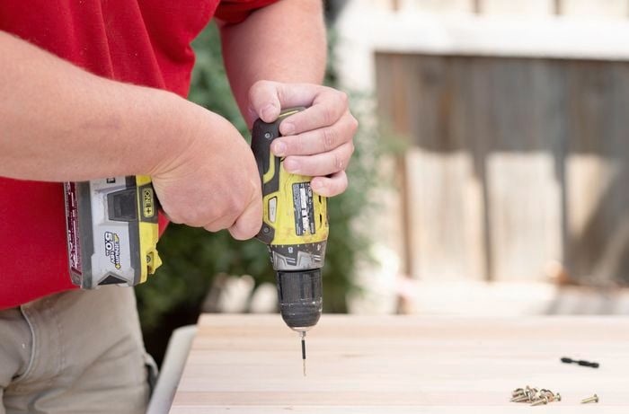 A Bunnings team member pre-drilling a piece of timber
