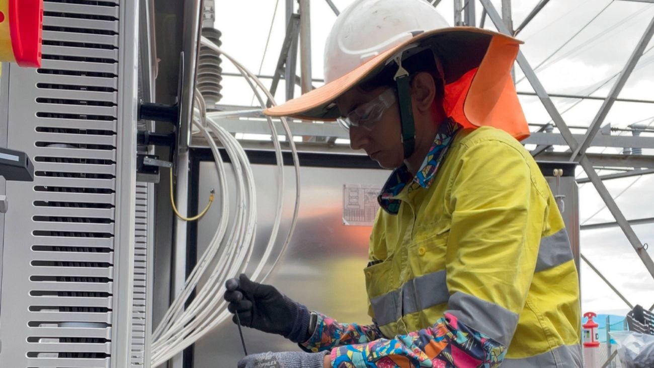 Women in construction advocate Faiza Nazar wearing hi-vis in Bunning Warehouse store with AEG power tools in the background