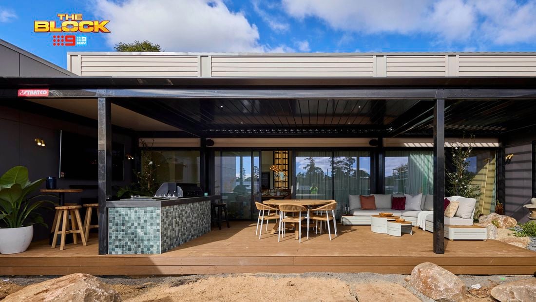 Back of a house with an outdoor setting, lounge and kitchen on decking.