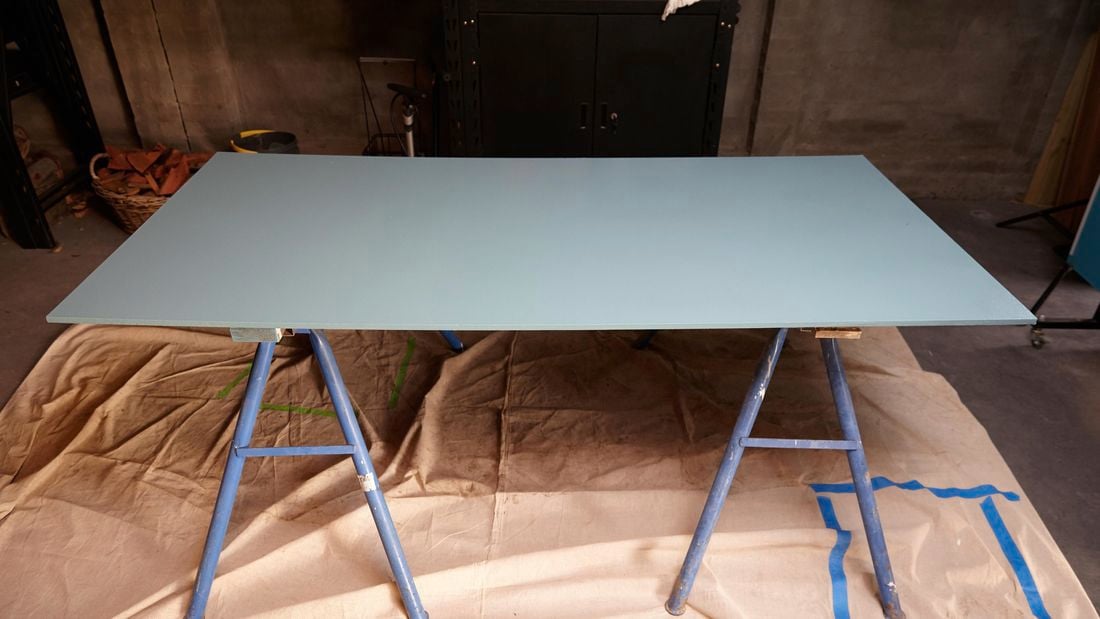 A painted sheet of MDF sitting on two saw horses