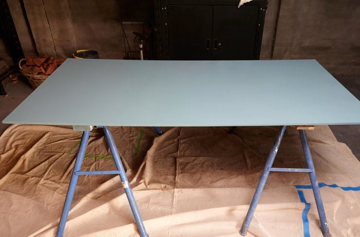 A painted sheet of MDF sitting on two saw horses