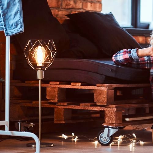Sofa pallet stack with wheels and lamp.